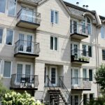 Peinture de fer forgé : faire soi-même ou engager un peintre professionnel ? 1 Immeuble résidentiel avec balcons en fer forgé noir et façade claire, typique d’un bâtiment à logements au Québec